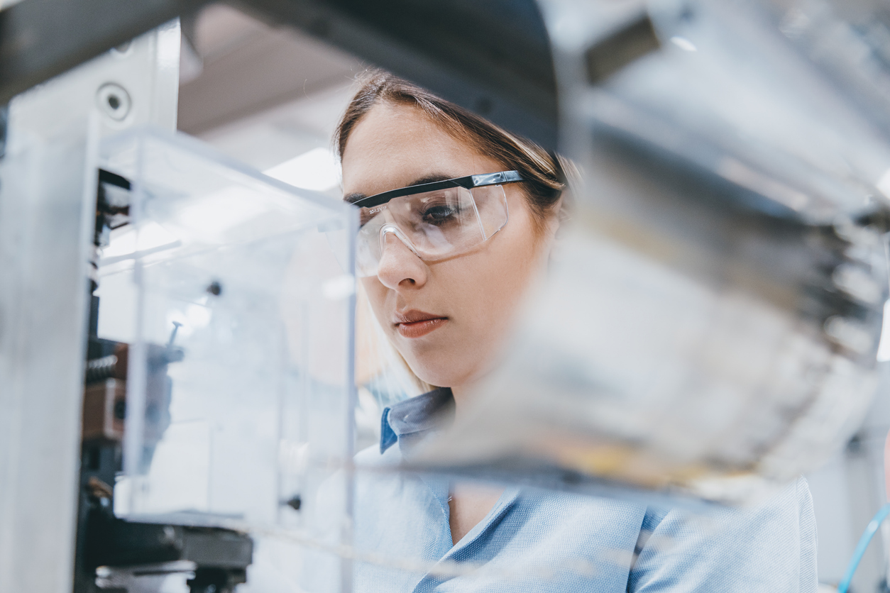 Woman researcher looking at specimen with a microscope